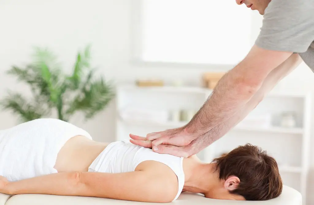 Woman receiving acupuncture and chiropractic care