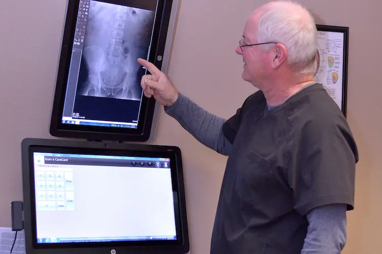 Dr. Randy Hinze, a chiropractor in Columbus, discussing his findings with one of his patients.